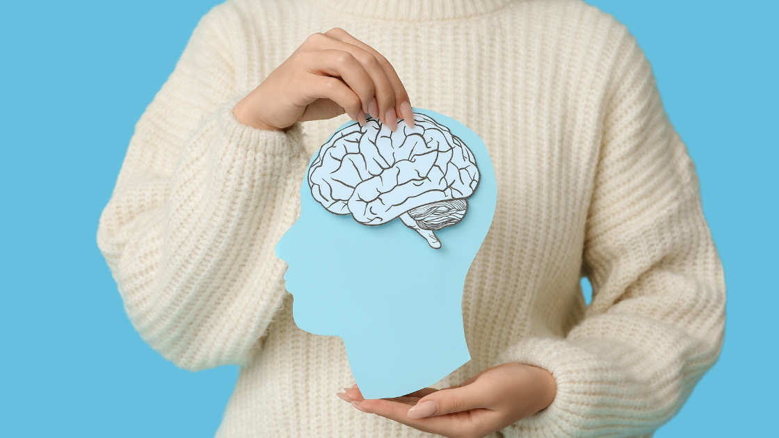 Person holding paper cut-out of a brain.